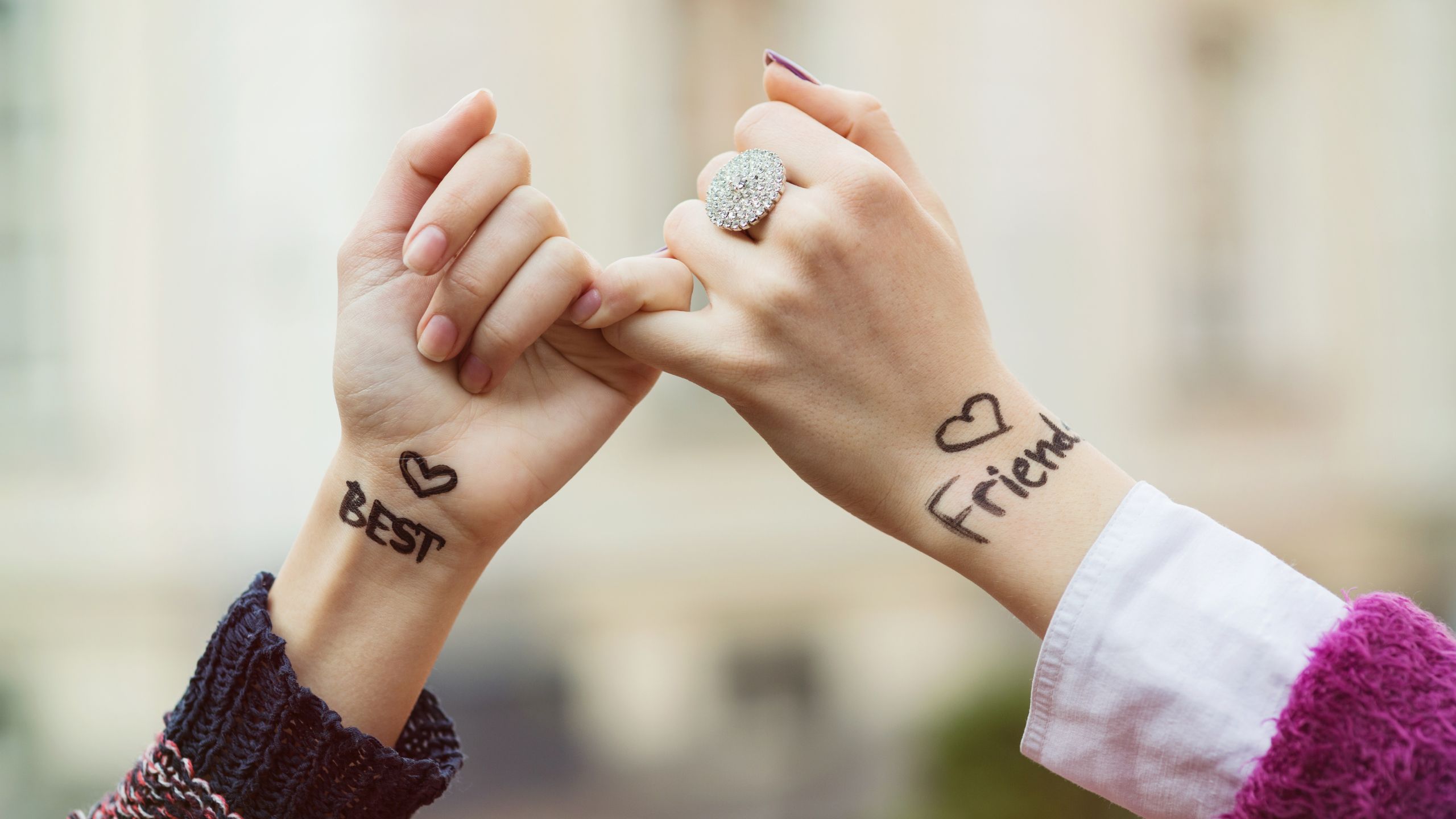 Best friends putting their hands together whilst being raised up