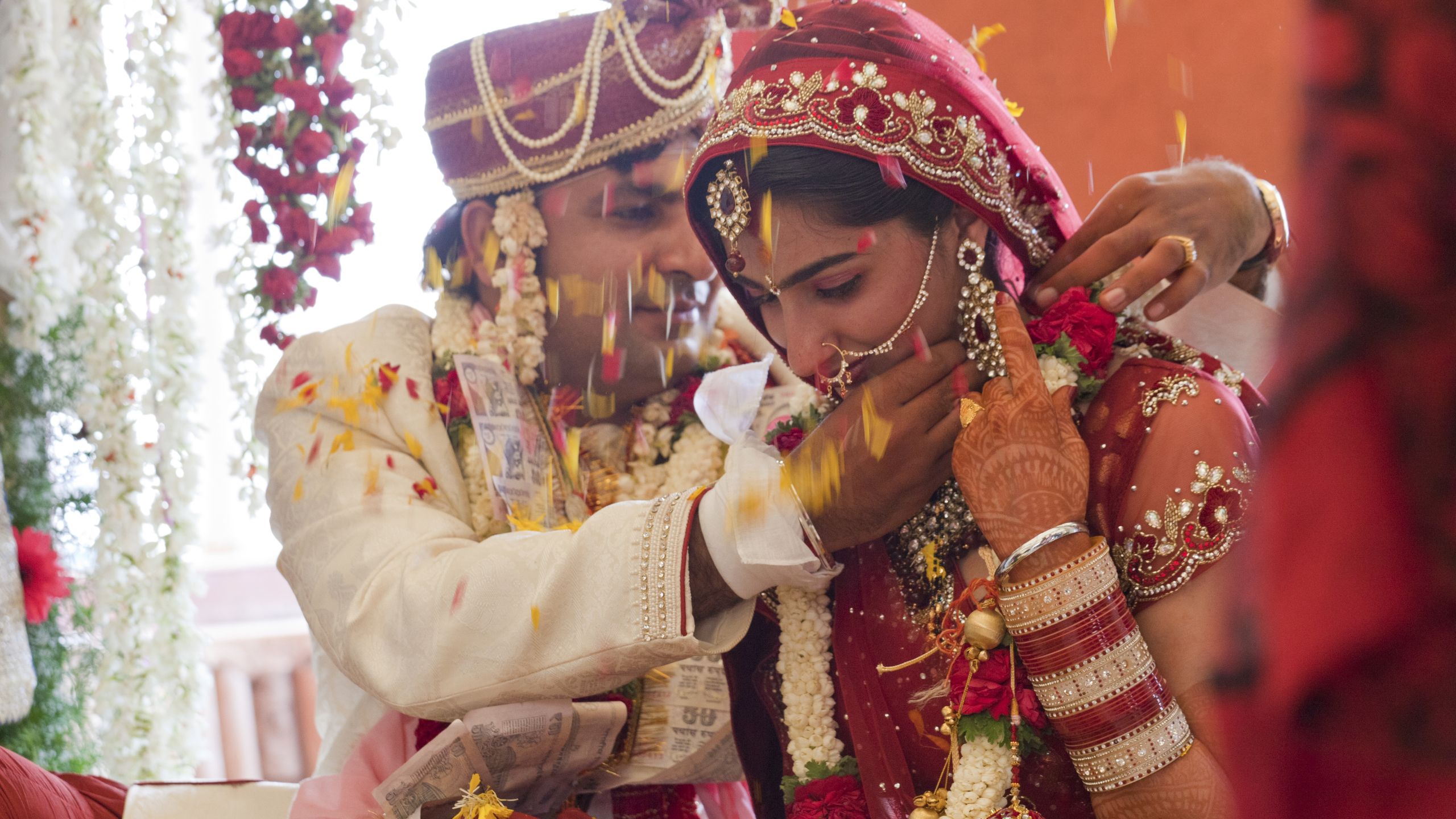 husband dressing up wife on their wedding day