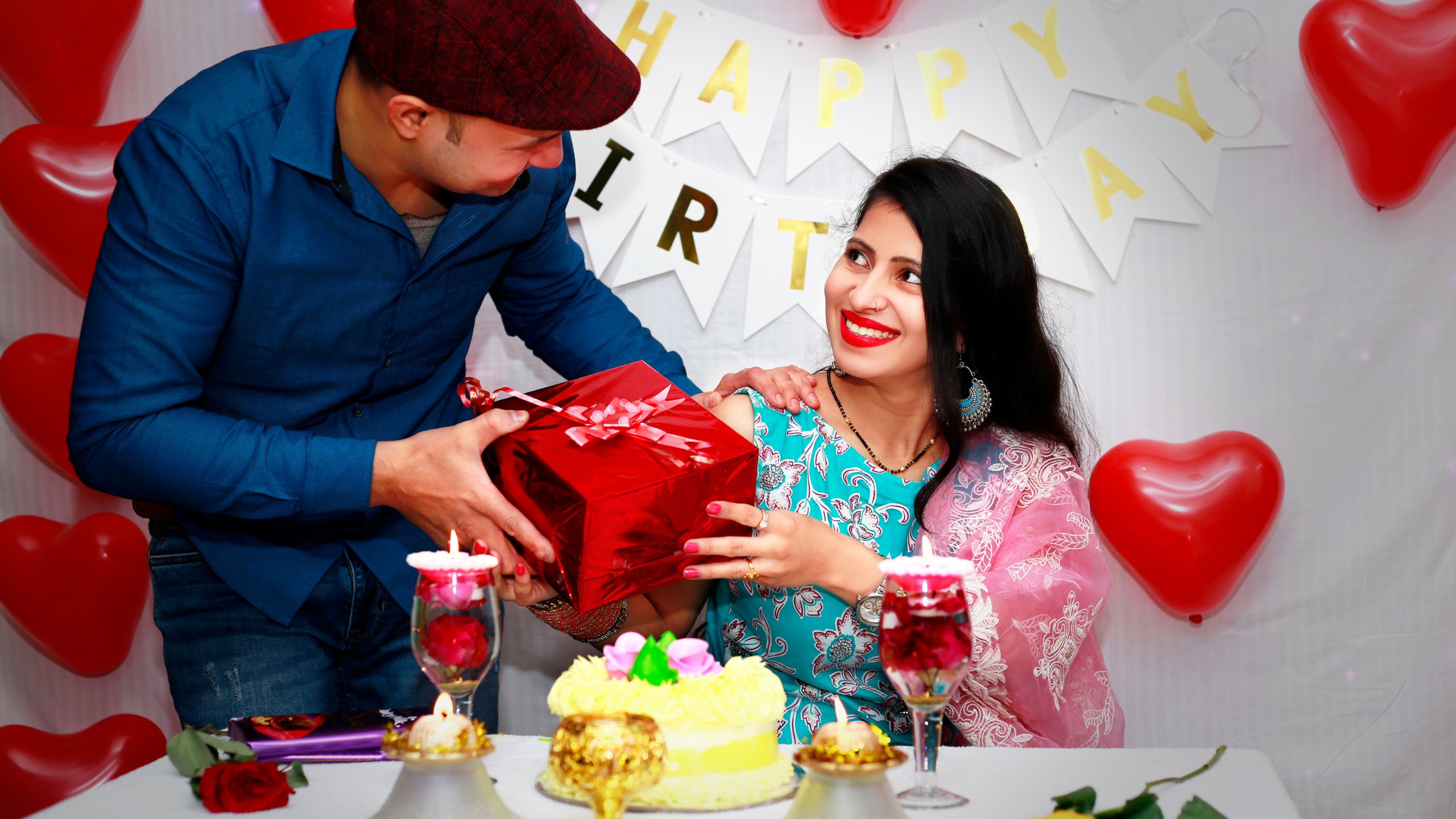 husband handing a birthday gift to his wife